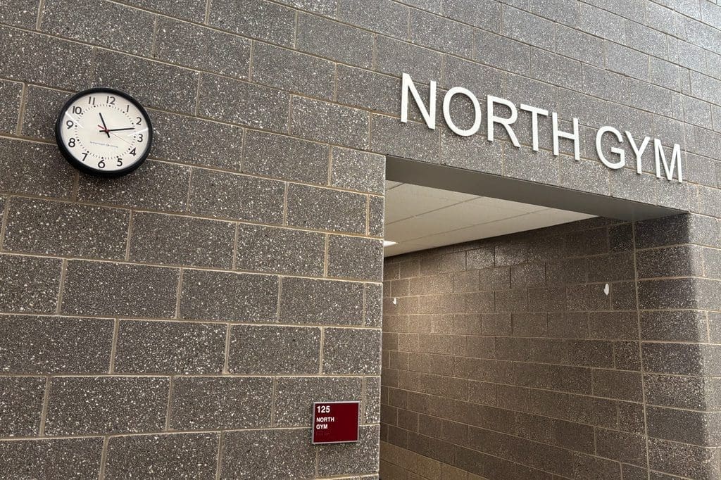 Gymnasium Entrance with synchronized clock on brick wall